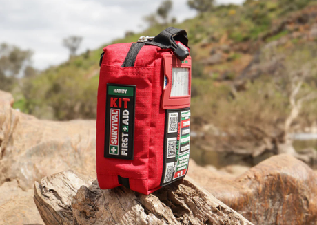 Red survival first aid kit in natural environment