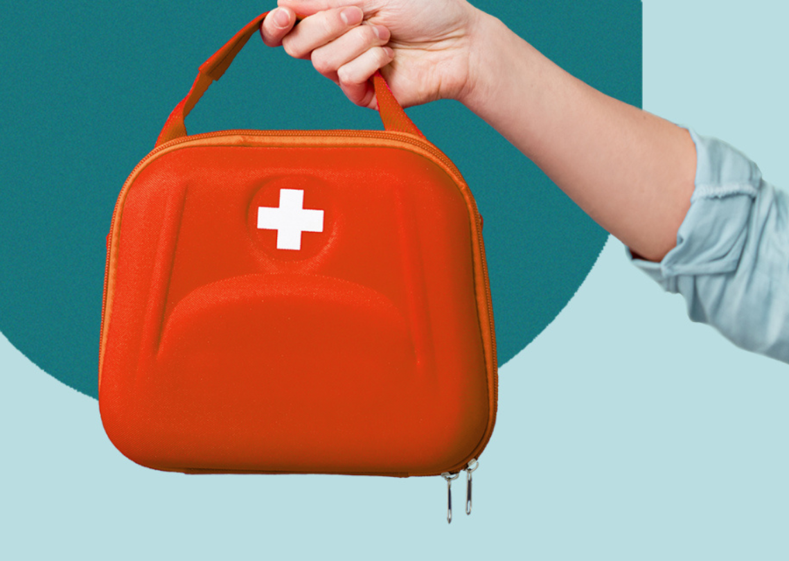Hand holding a red first aid bag
