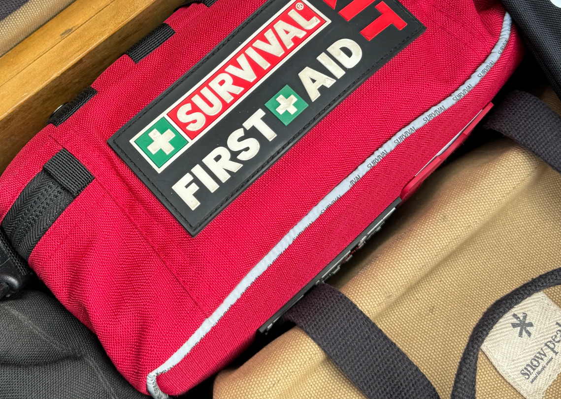 Survival first aid kit placed alongside other bags