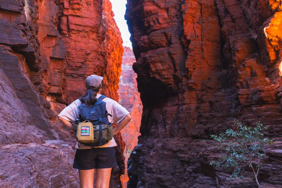 Hiker walking into a remote gorge with the Snake Bite KIT on her pack